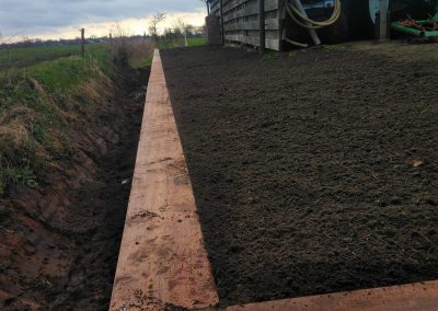 Beschoeiing van hout langs sloot en schuur