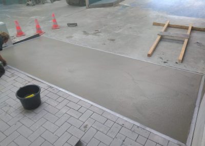 Cementvloer naast tegelwerk en betonvloer