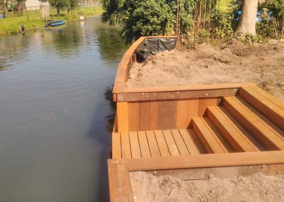 Houten damwand met houten trap naar de waterkant