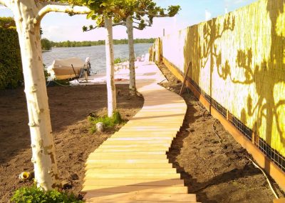 Zon schijnend op bamboe schutting en houten pad