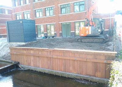 Hoge damwand aan tuin van nieuwbouw huis