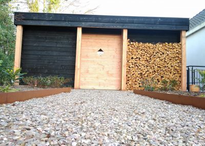 Schuur voor brandhout met zwart hout