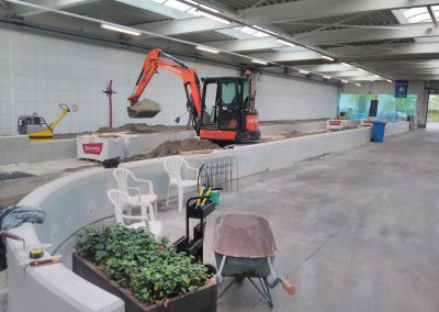 Graafmachine aan het werk met zand en beton