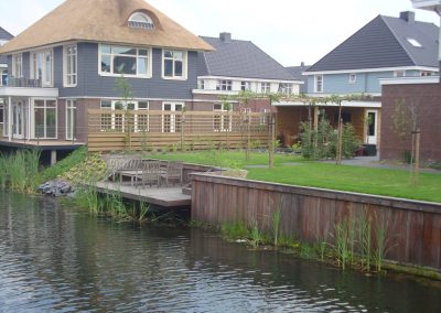 Damwand in een tuin met terras over het water