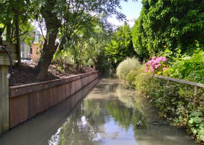 Damwand achterin de tuin bij de sloot